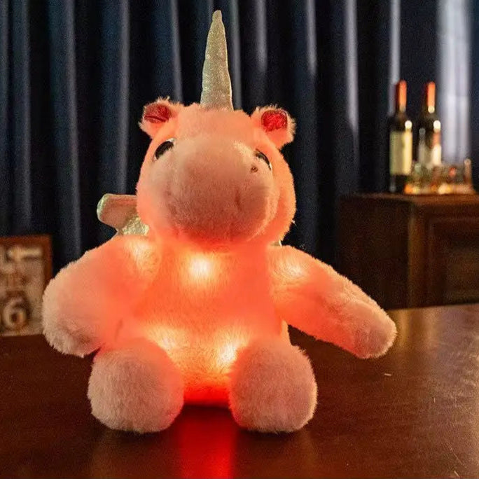 peluche licorne lumineuse rose sur la table