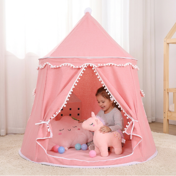 Enfant jouant avec une peluche dans la tente tipi rose curtent