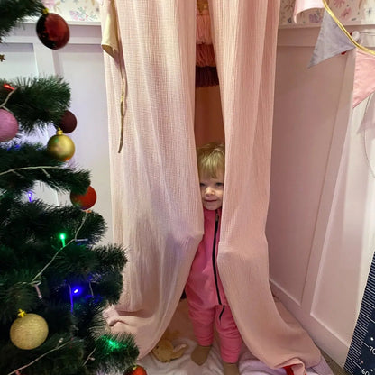 enfant dans ciel de lit rose PinkDais