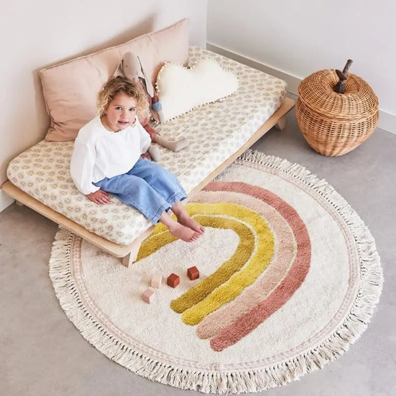 tapis arc en ciel bande rose au pied du lit d'enfant