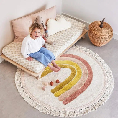 tapis arc en ciel bande rose au pied du lit d'enfant